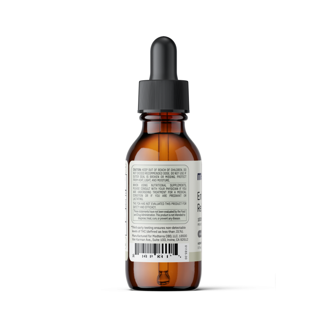 A brown glass dropper bottle with a black cap is shown from the back, displaying a white label with various text and a barcode. The bottle appears to contain an amber-colored liquid product, likely Enhanced Relief Broad Spectrum CBD Oil from Medterra, which emphasizes the entourage effect for cosmetic or medical use.